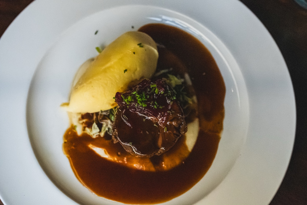 Braised beef with mash and greens, seen from above