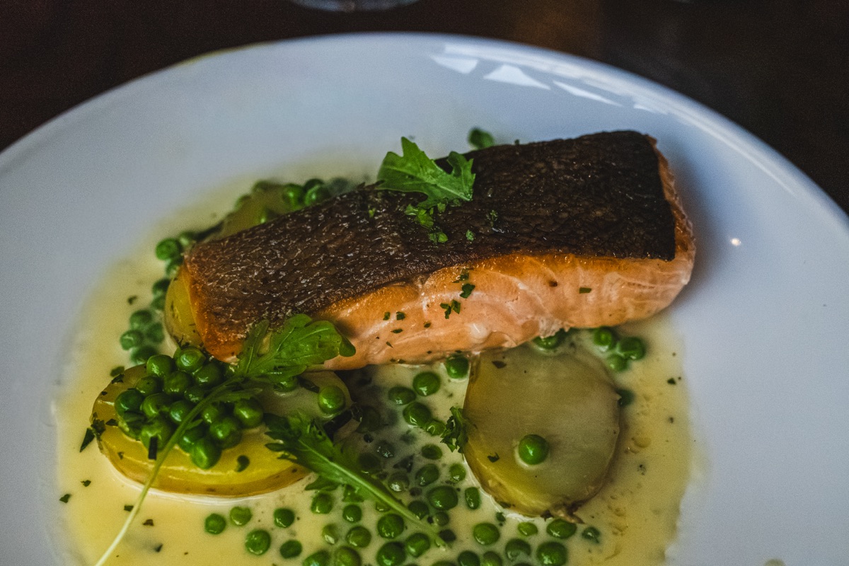 Pan roasted salmon fillet on crushed potatoes and peas