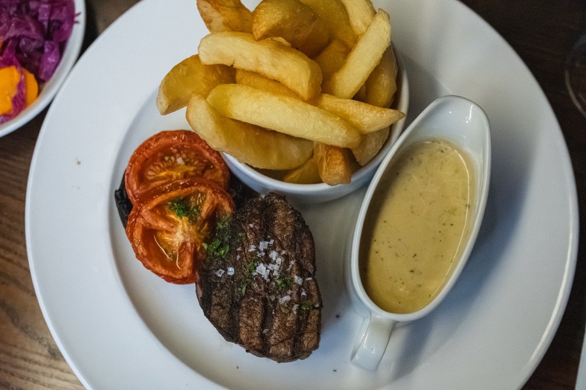 Steak with chips, grilled tomato and peppercorn sauce