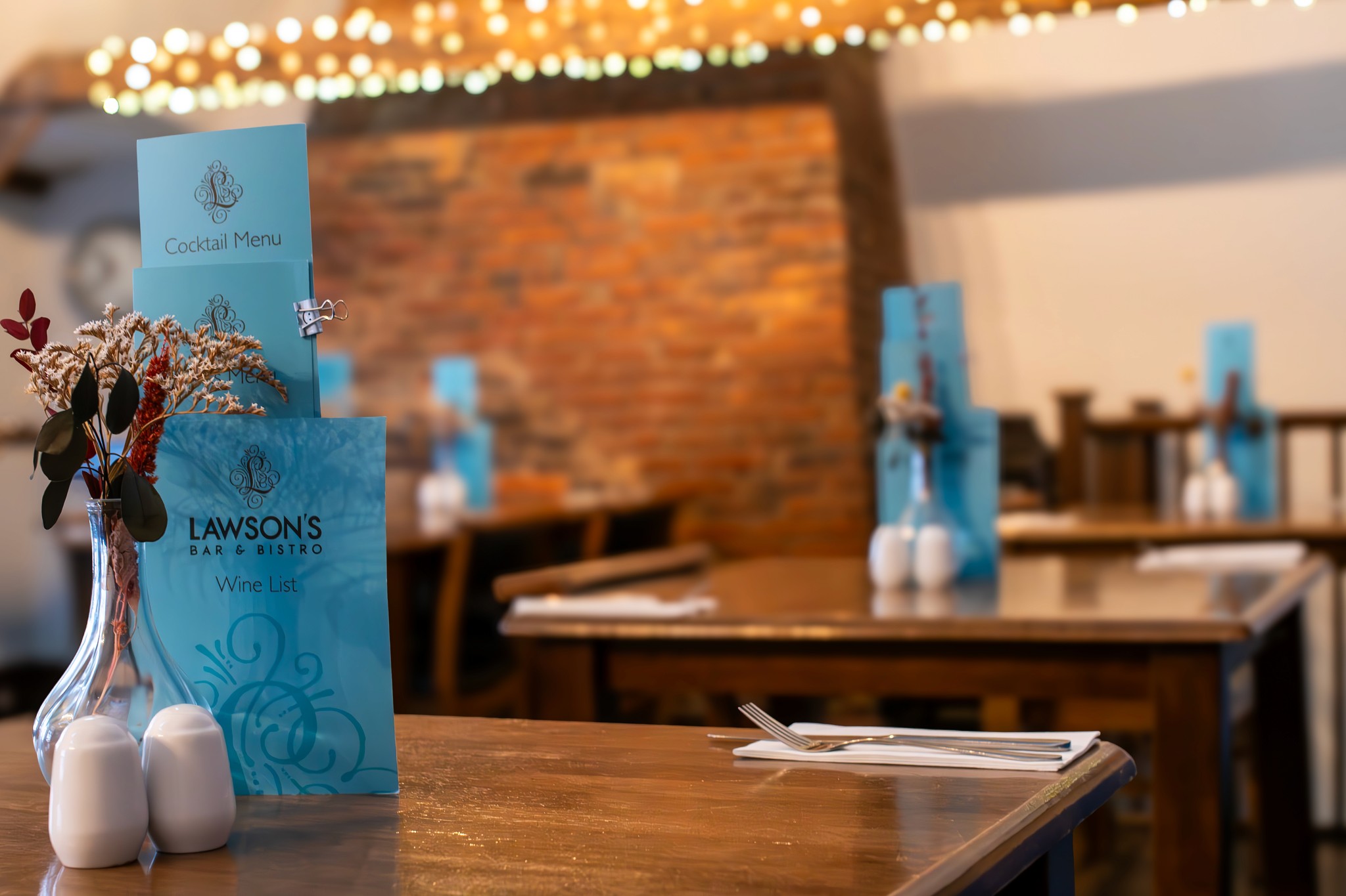 The turquoise cocktail and wine menus on a table in the dining room at Lawson's